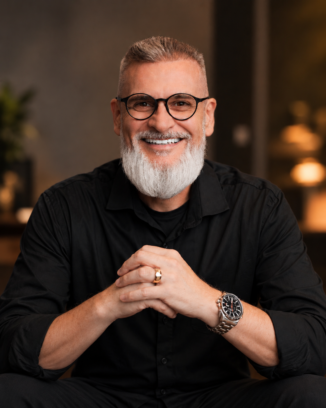 Alexandre Pscheidt sorrindo, de camisa preta, em ambiente com iluminação quente